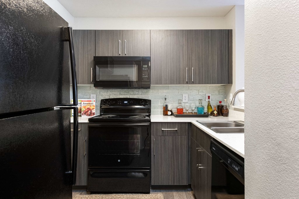 a kitchen with black appliances and dark wood cabinets
