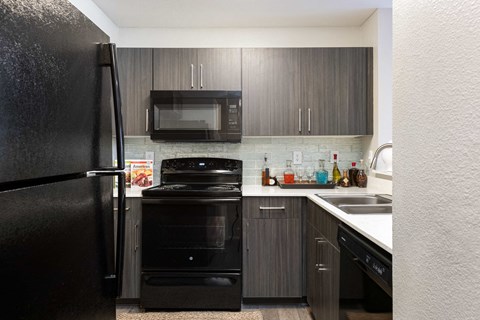 a kitchen with black appliances and dark wood cabinets