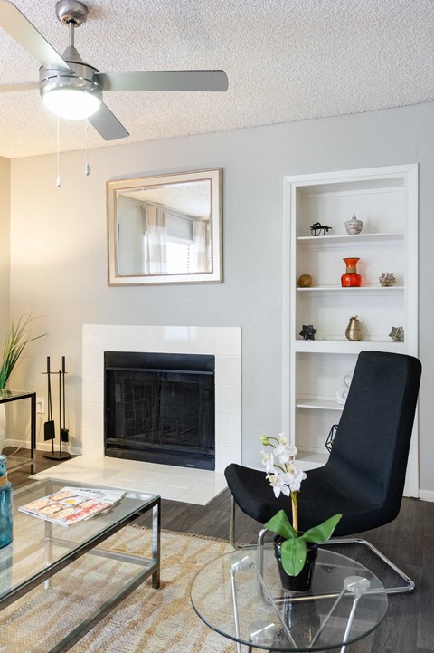 a living room with a fireplace and a table and a chair