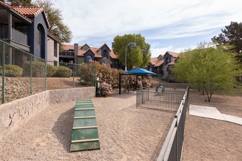 a fenced in area with a playground and a picnic table
