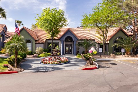 the front of a house with a driveway and trees and plants