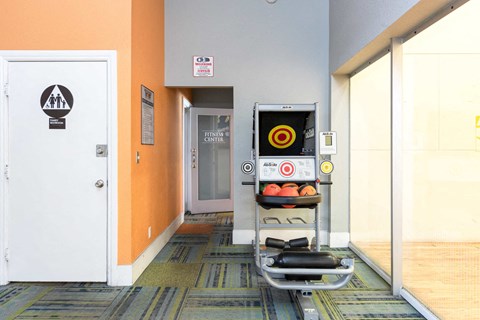 a gym with a punching bag and weights in a room with a door