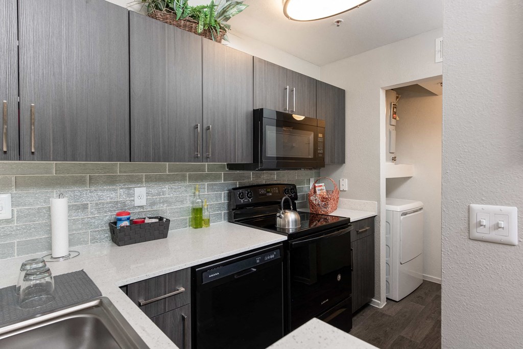 a kitchen with black appliances and white counter tops