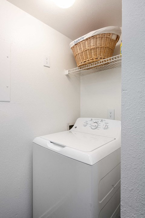 a white washer and dryer in a laundry room with a basket on top