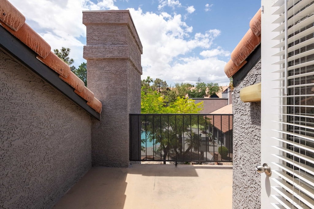 a balcony with a view of a pool and a gate