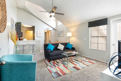 a living room with a couch and a ceiling fan