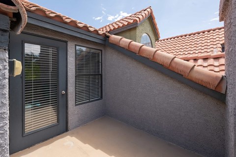 a patio outside of a house with a door and a window