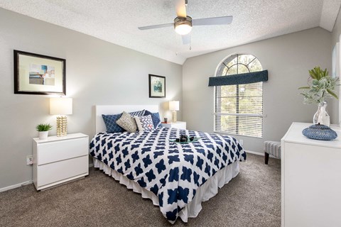 a bedroom with a bed and a ceiling fan