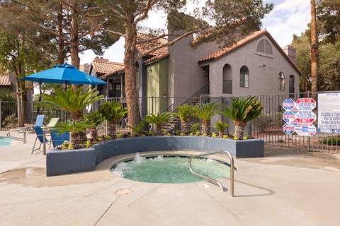 a hot tub in a pool in front of a house