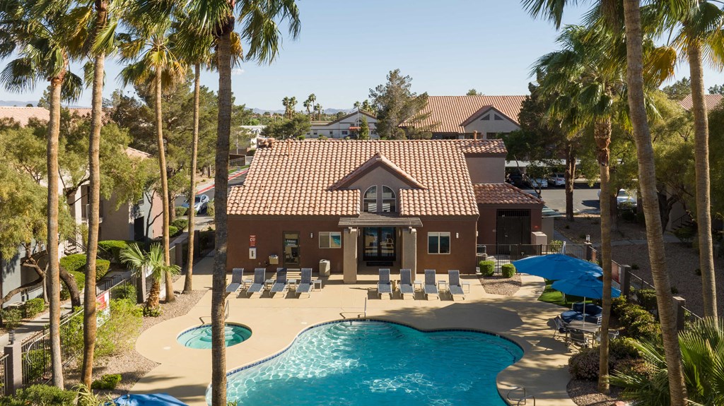 a house with a pool and chairs in front of it