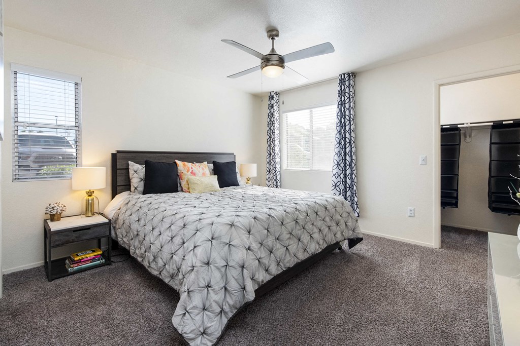 a bedroom with a bed and a ceiling fan