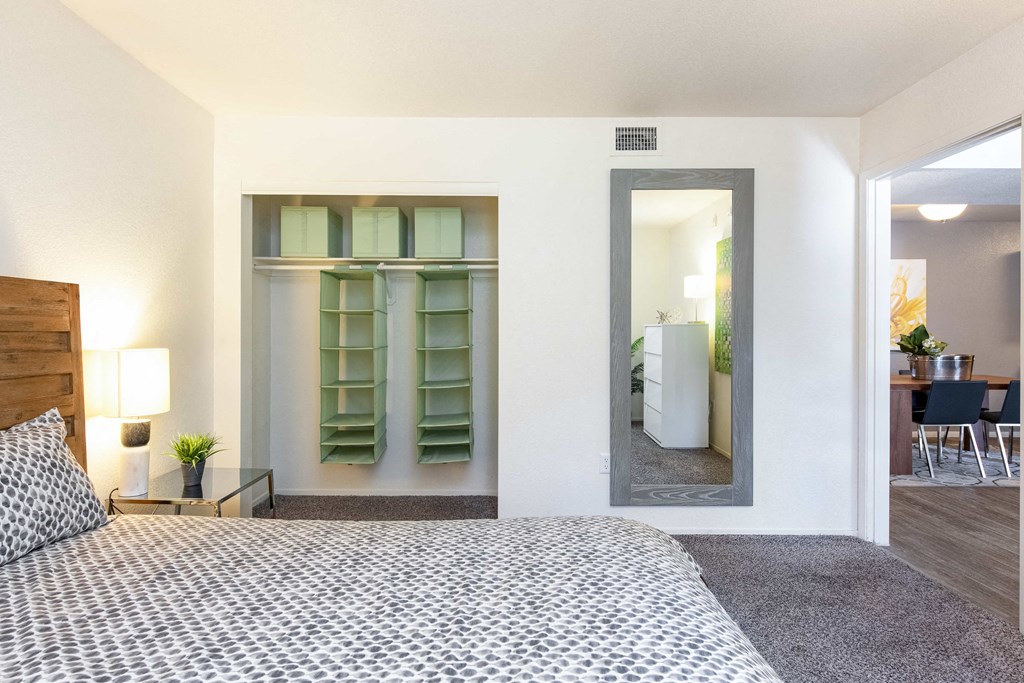 a bedroom with a large bed and a closet with a mirror