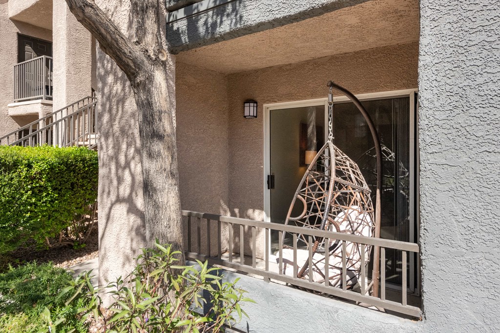 the front porch of an apartment building with a swing on it