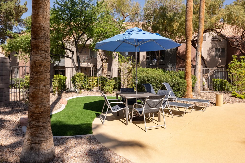 a patio with a table and chairs and an umbrella
