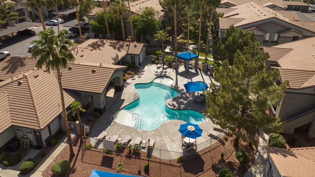 an aerial view of a resort style swimming pool with umbrellas