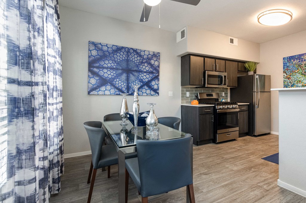 a dining room with a table and chairs and a kitchen