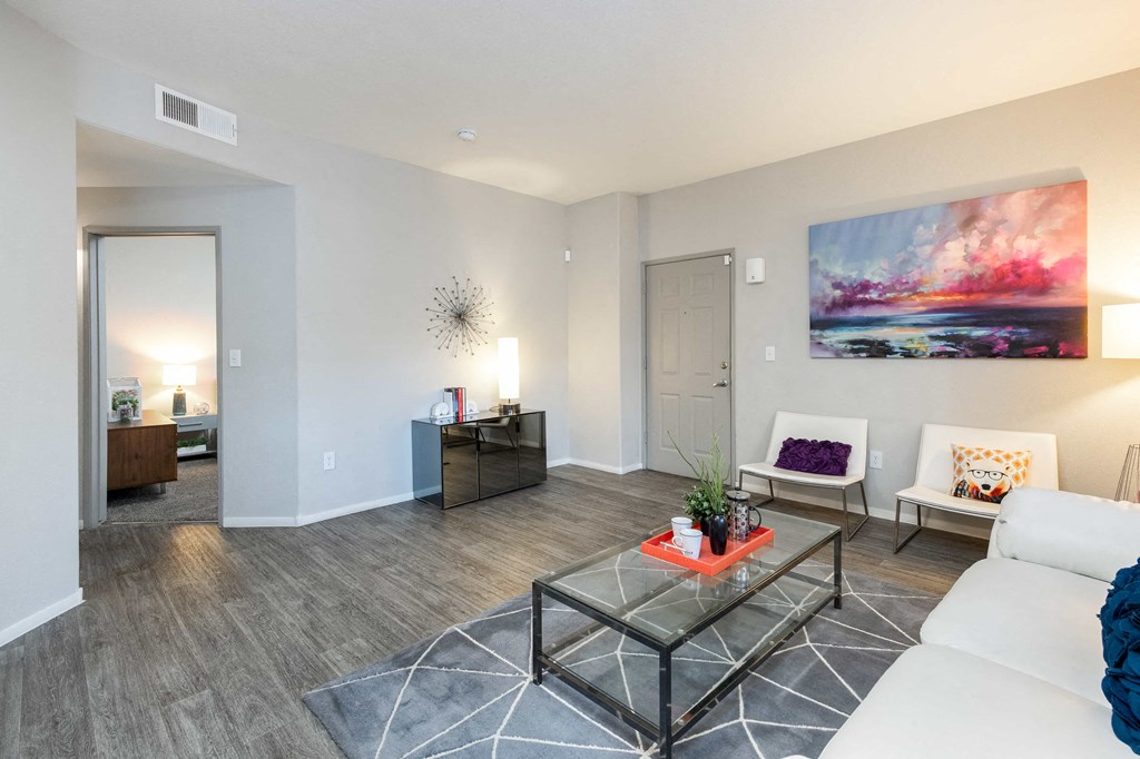 a living room with white furniture and a glass coffee table