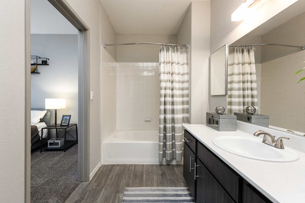 a bathroom with a shower and a sink and a mirror