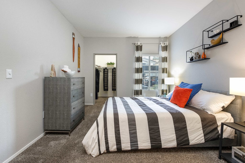 a bedroom with a bed and a dresser and a window