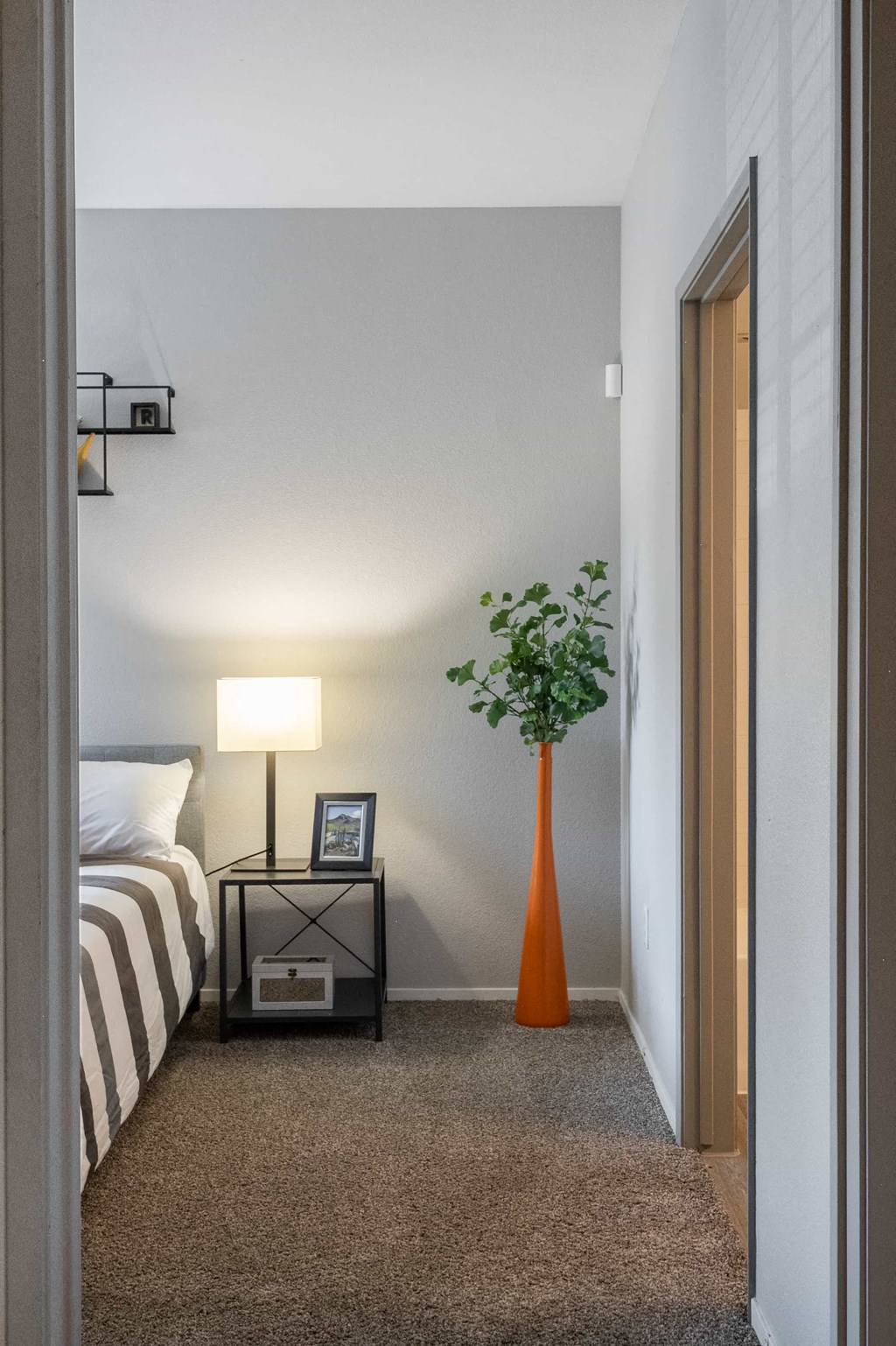 a bedroom with a bed and a vase with a plant