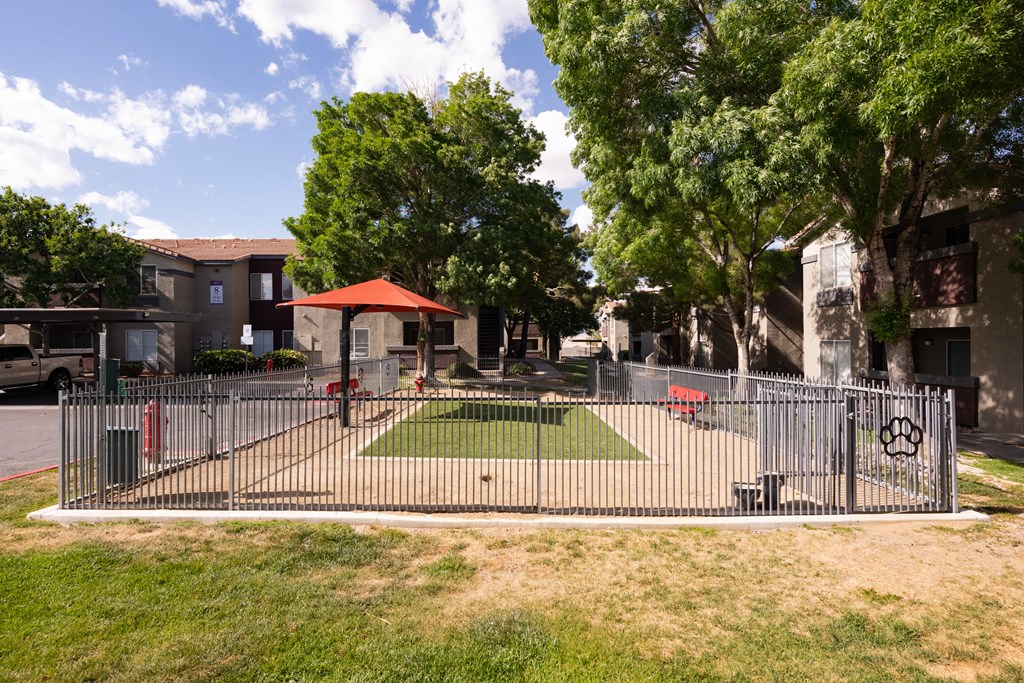 a fenced in area with a lawn and a pool behind a fence