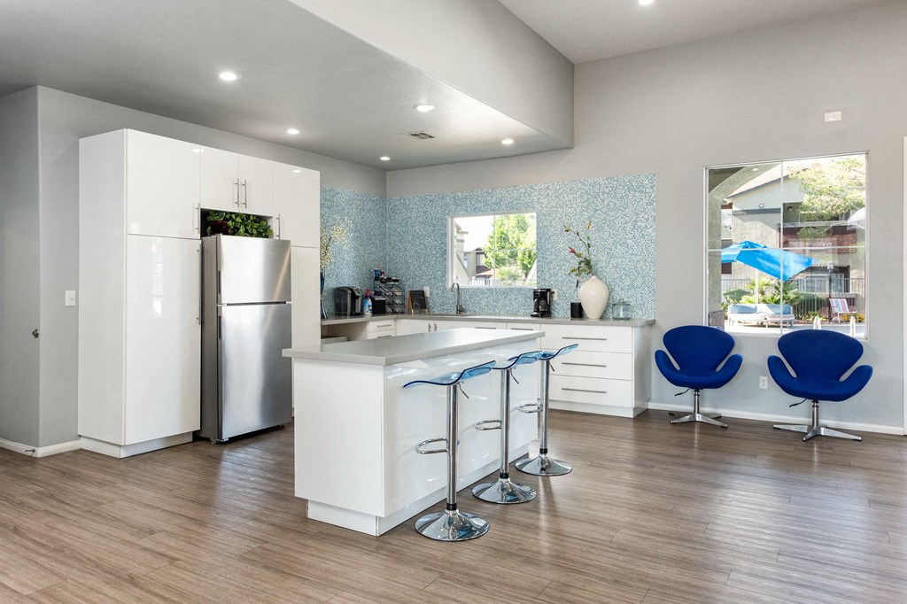 a kitchen with an island and blue chairs