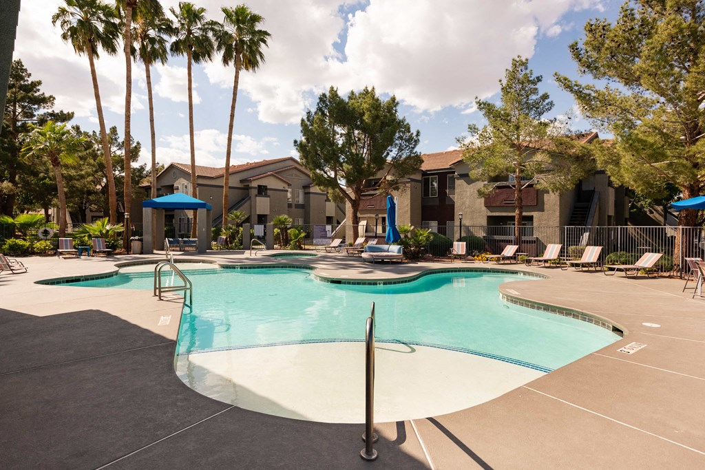 our apartments have a large swimming pool with chairs and umbrellas