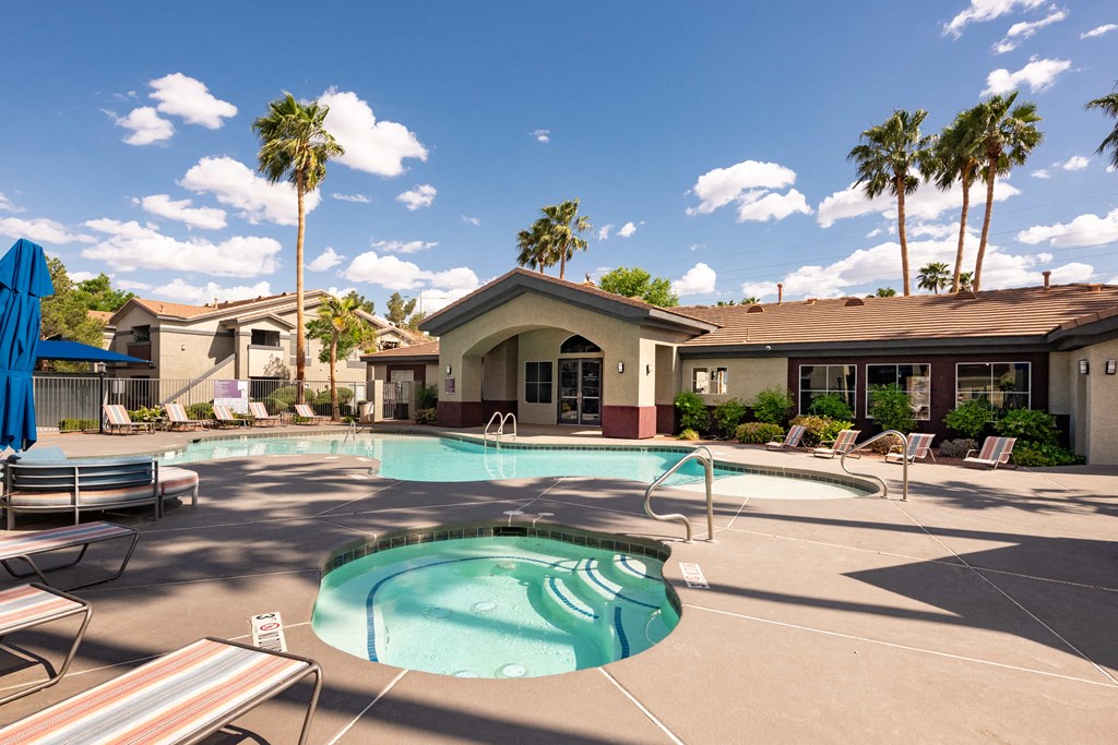 our resort style pool is surrounded by chairs and palm trees