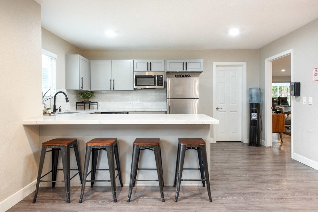 a kitchen with a large island with three stools
