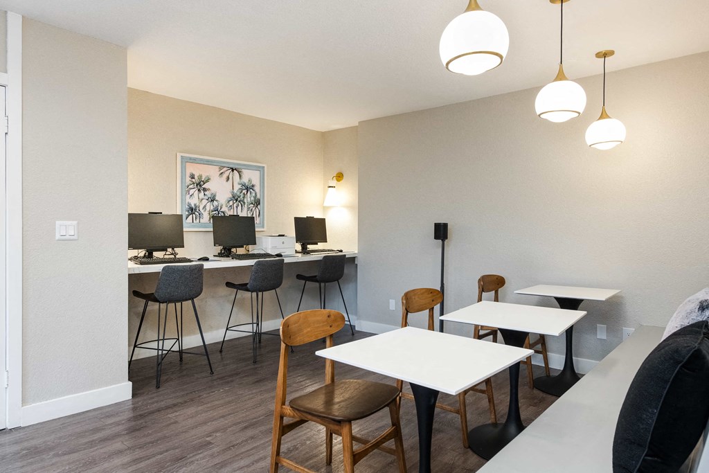 a dining room with tables and chairs and a counter with lamps