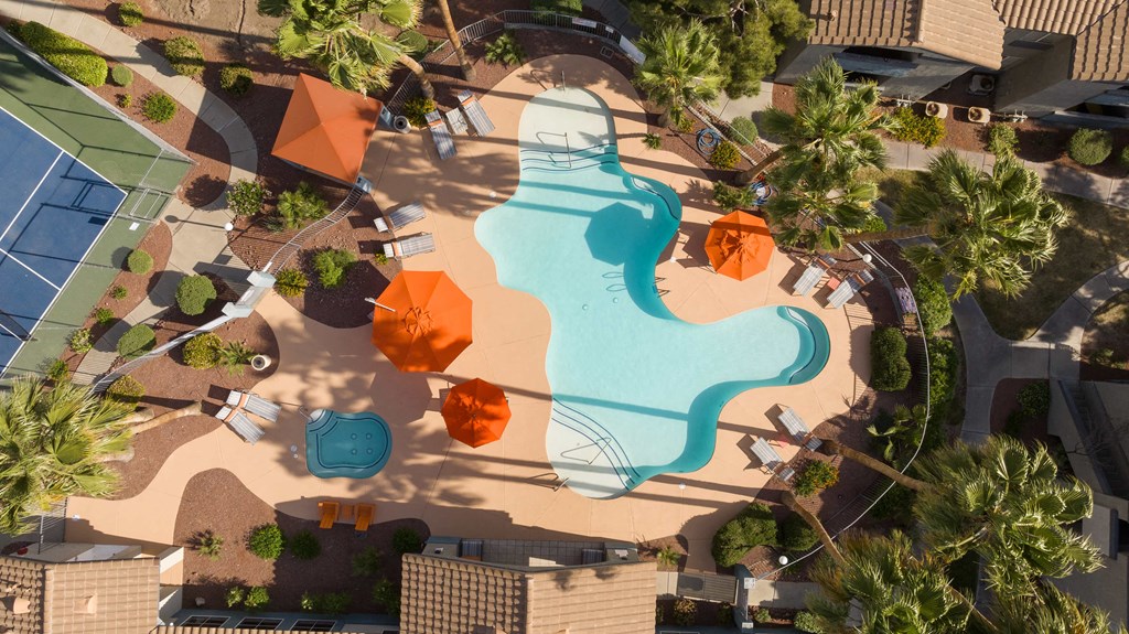 an overhead view of a swimming pool at a resort with umbrellas