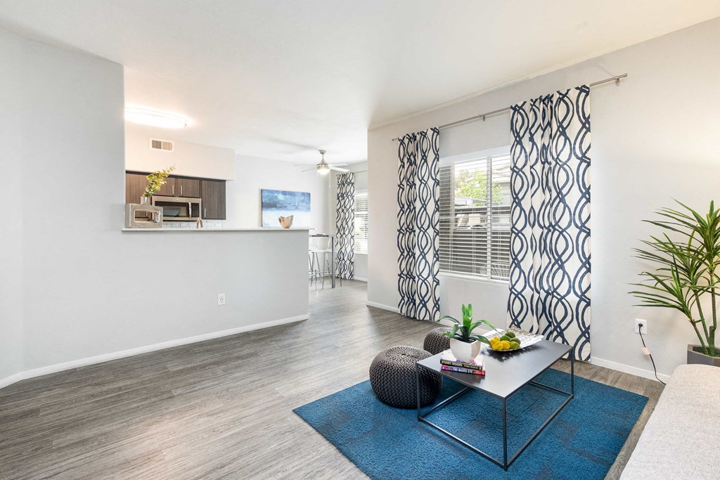 a living room with a table and a kitchen