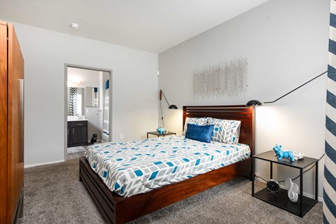 a bedroom with a bed and a dresser and a bathroom