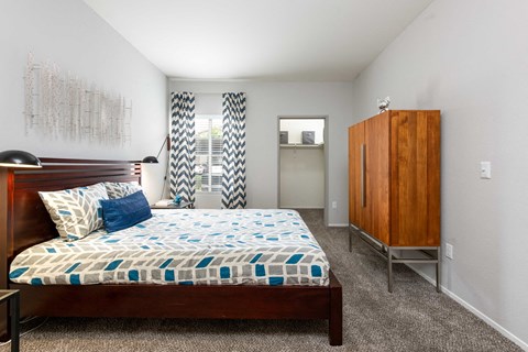 a bedroom with a bed and a dresser and a window