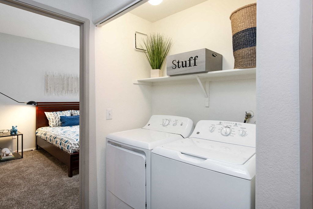 a white washer and dryer in a room with a bedroom