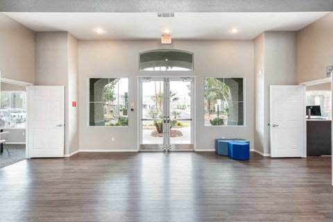 an empty living room with white doors and a hard wood floor