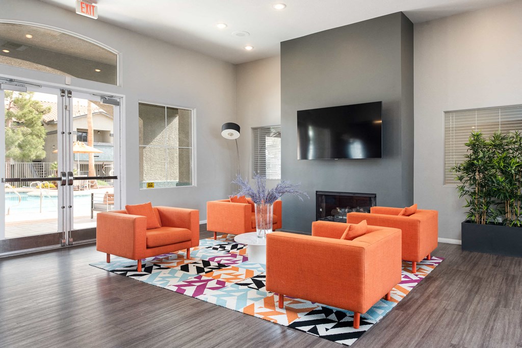 a living room with orange chairs and a television     and a pool