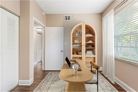A dining room with a wooden table and chairs.