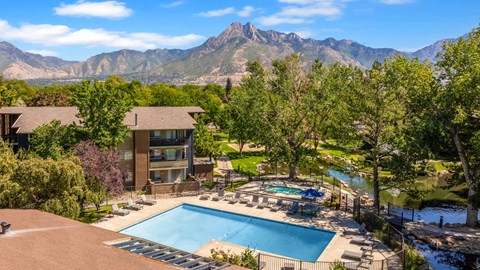 an aerial view of a swimming pool with mountains in the background