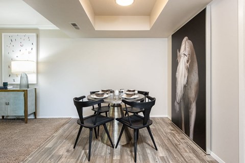 a dining room with a table and chairs and a large wall mural of an elephant