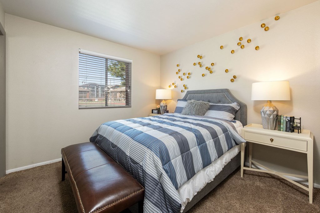 a bedroom with a blue and white bed and a window