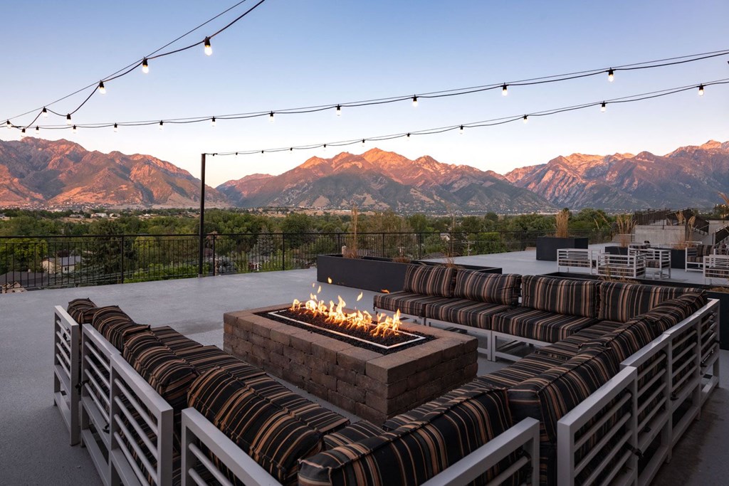 a fire pit on a patio with mountains in the background