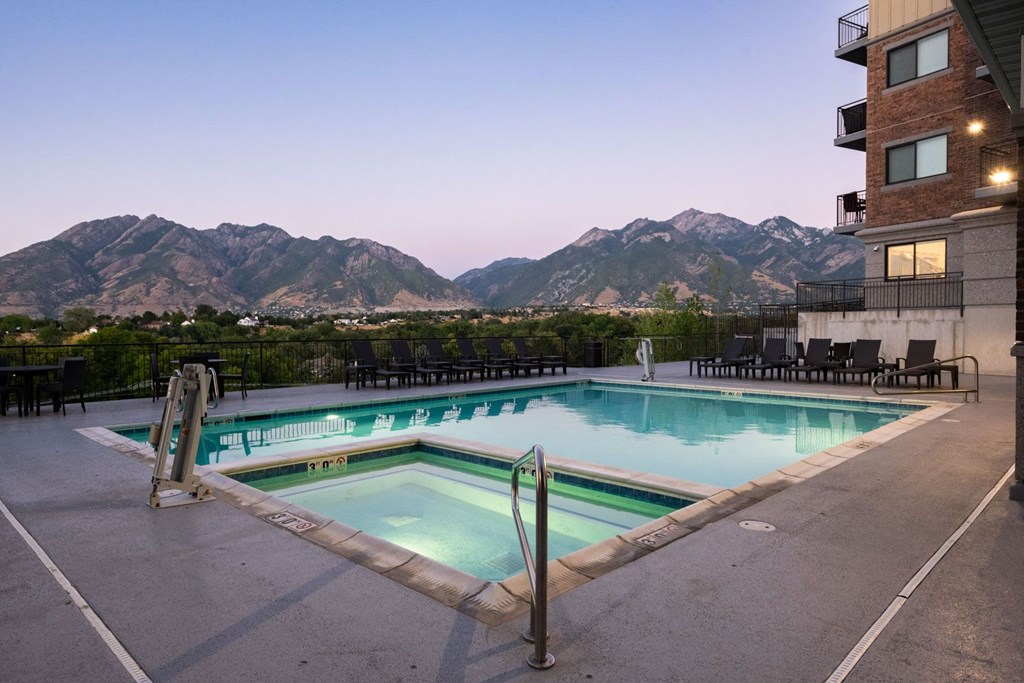 a swimming pool at a hotel with mountains in the background