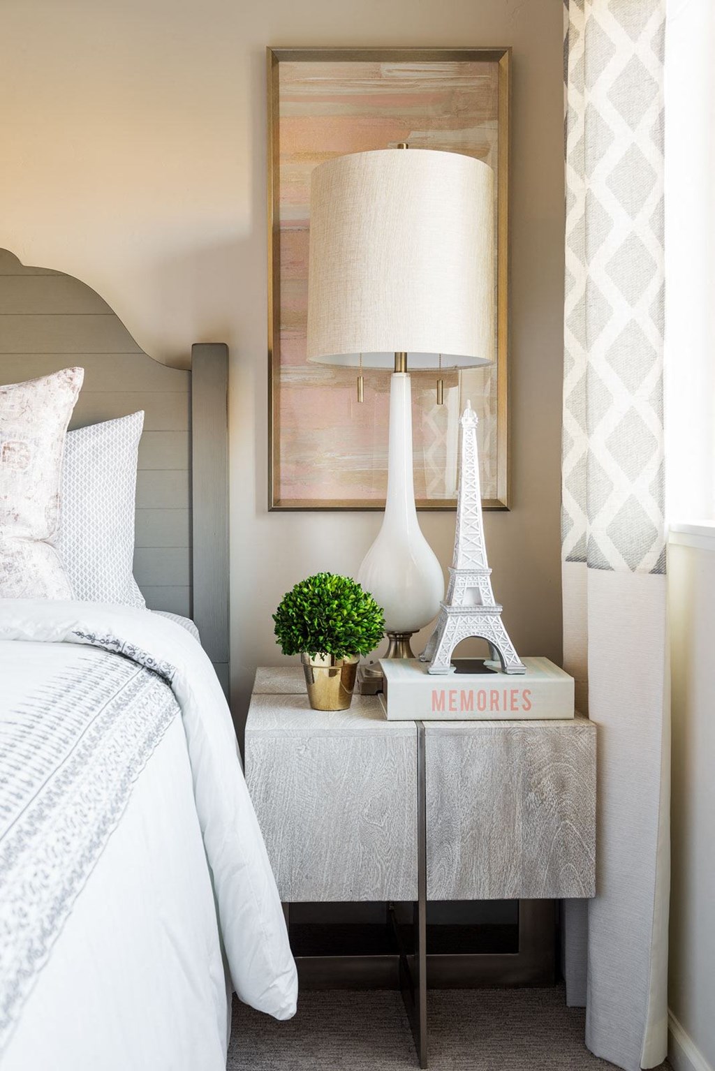 a bedroom with a bed and a nightstand with a plant and a lamp