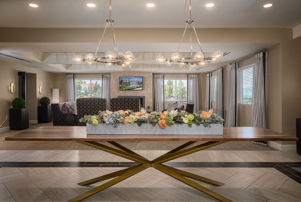 a lobby with a table with flowers on it