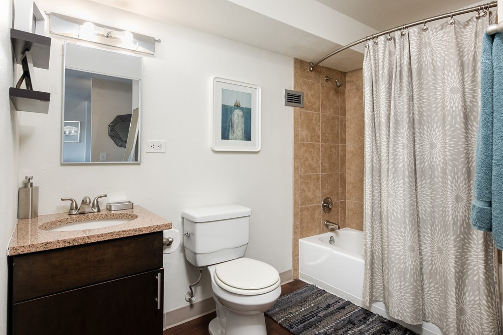 A bathroom with a toilet, sink, and shower.