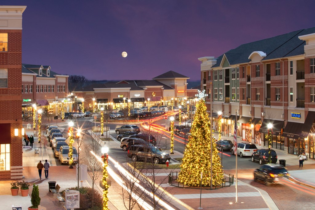 a city street decorated with a christmas tree at night