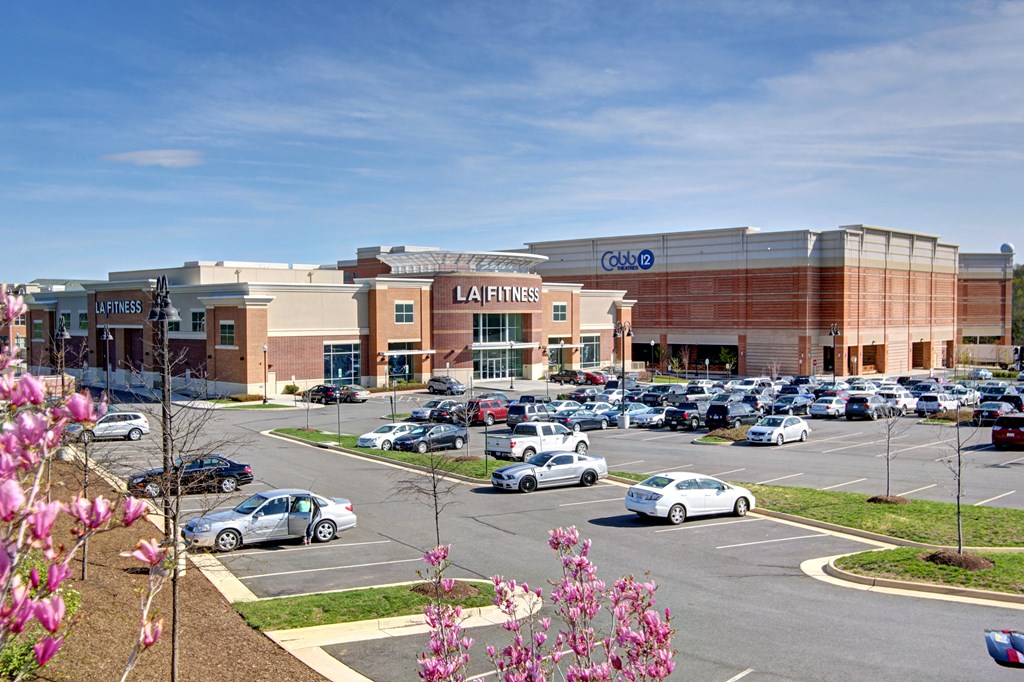 a shopping center with cars parked in a parking lot