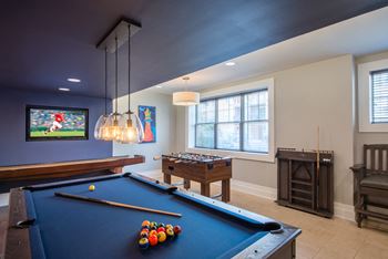 a game room with a pool table and a tv