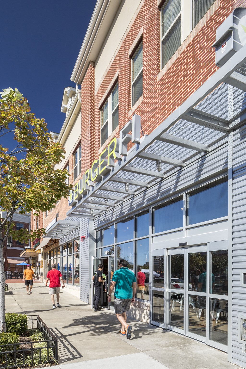 people walking down a sidewalk in front of a grocery store
